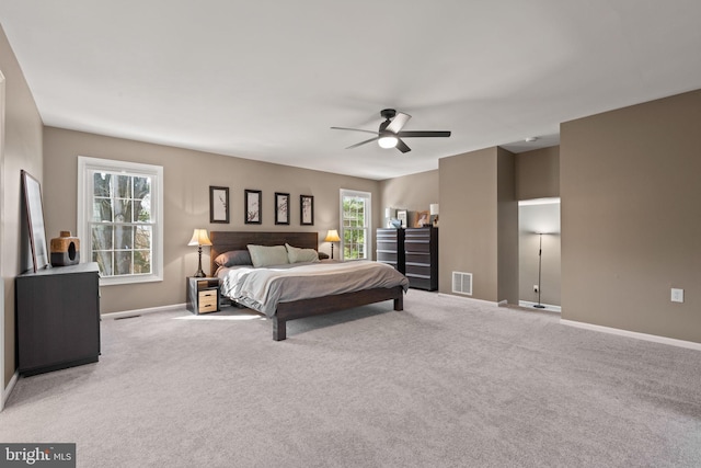 carpeted bedroom featuring multiple windows and ceiling fan