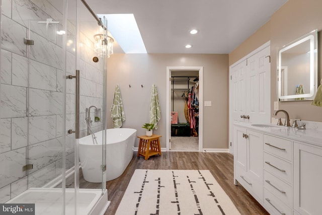 bathroom with a chandelier, a skylight, vanity, independent shower and bath, and hardwood / wood-style flooring