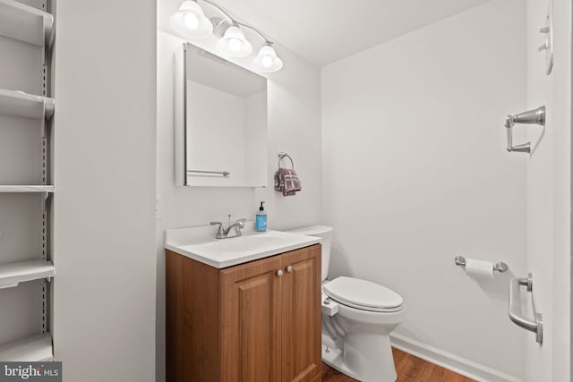 bathroom featuring hardwood / wood-style flooring, vanity, and toilet