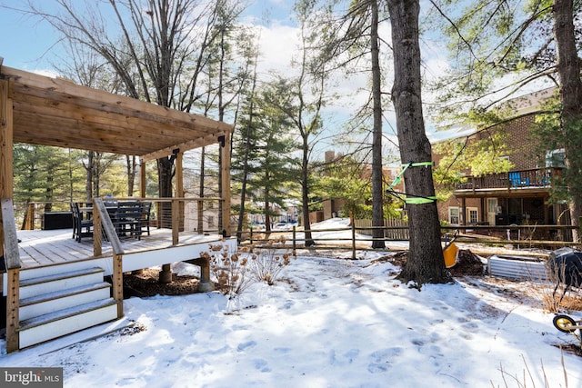 yard layered in snow with a pergola and a deck