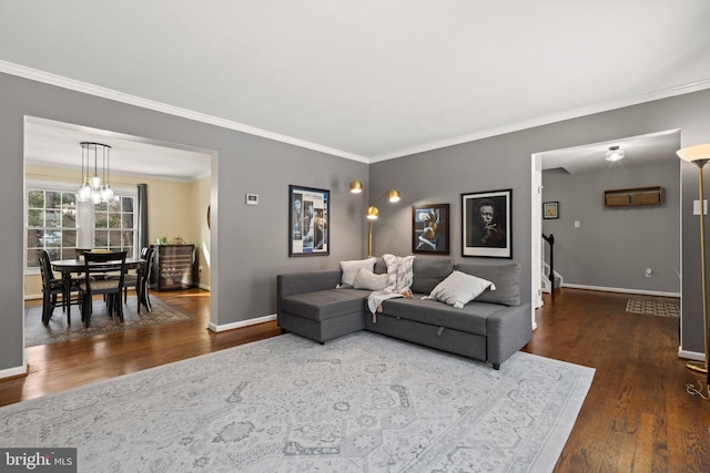 living room featuring ornamental molding, dark wood-type flooring, and a notable chandelier