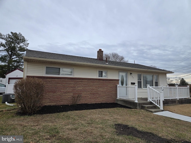 view of front facade featuring a wooden deck, central AC, and a front lawn