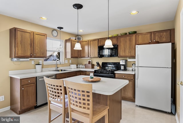 kitchen featuring black appliances, pendant lighting, a kitchen island, and sink