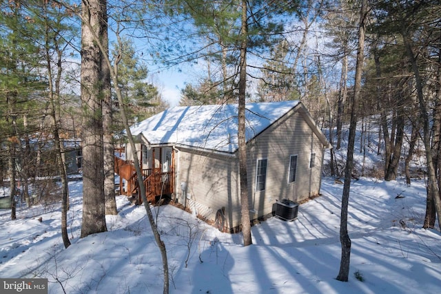 snow covered rear of property with central AC