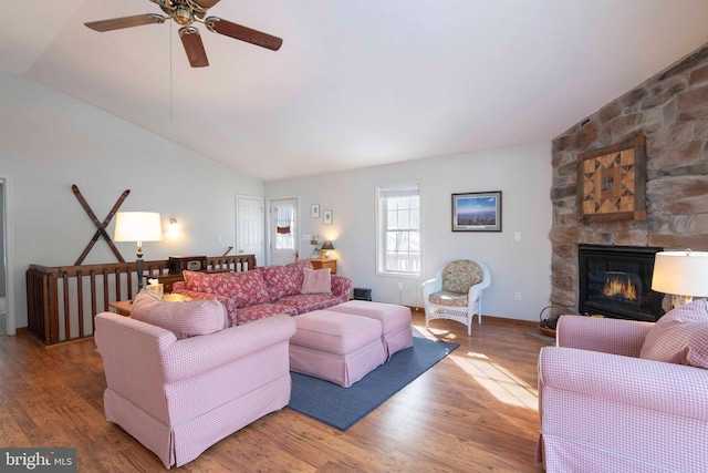 living room featuring lofted ceiling, a fireplace, ceiling fan, and hardwood / wood-style floors