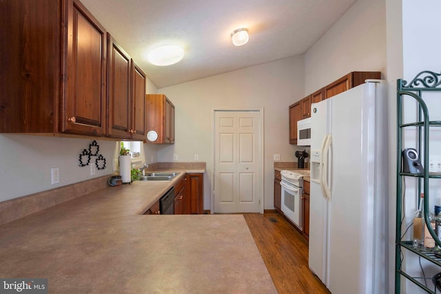 kitchen featuring white appliances, hardwood / wood-style floors, kitchen peninsula, sink, and lofted ceiling