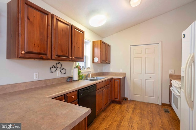 kitchen with sink, lofted ceiling, white appliances, and light wood-type flooring