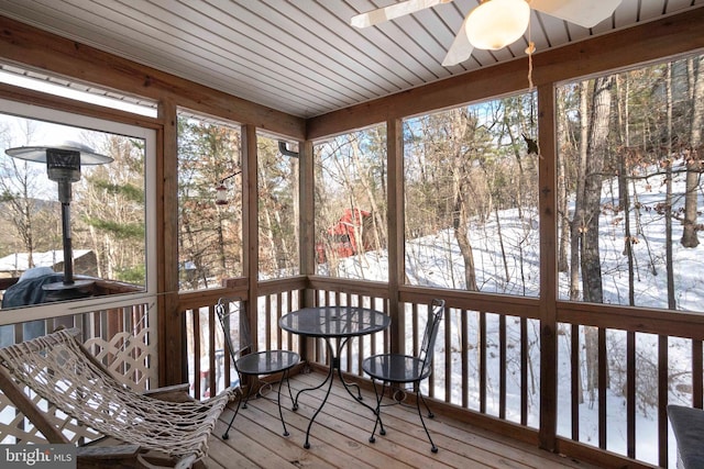 unfurnished sunroom featuring ceiling fan and a wealth of natural light