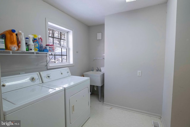 clothes washing area with washer and dryer and sink