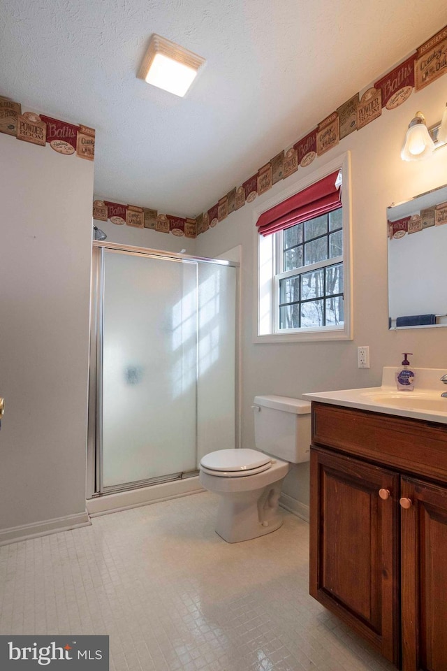 bathroom with toilet, an enclosed shower, vanity, and a textured ceiling