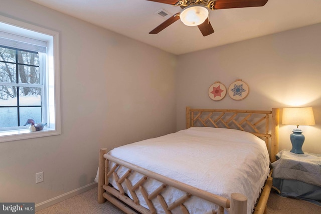 carpeted bedroom featuring multiple windows and ceiling fan