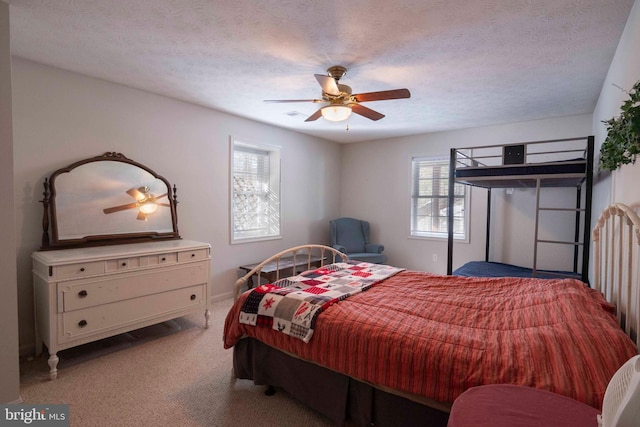 carpeted bedroom with a textured ceiling and ceiling fan