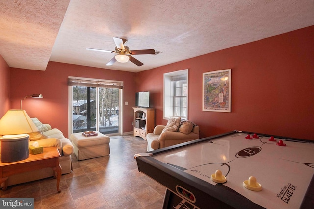 rec room with a textured ceiling and ceiling fan