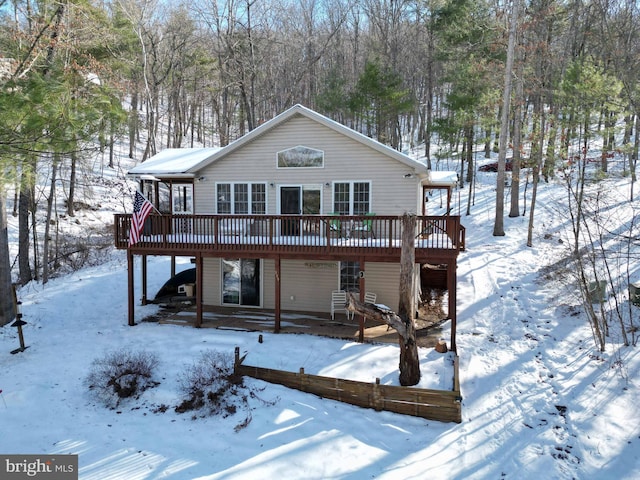 snow covered house with a wooden deck