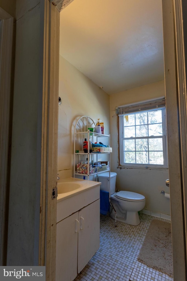 bathroom with tile patterned flooring, vanity, and toilet