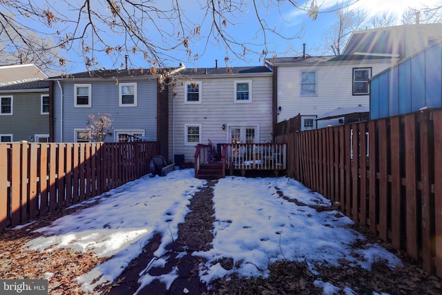 snow covered property with a wooden deck