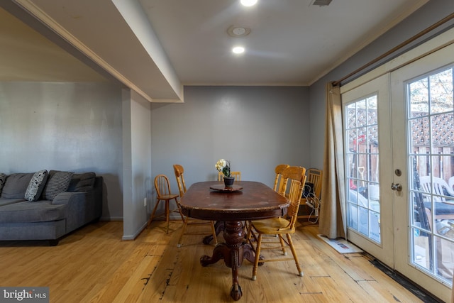 dining room with light hardwood / wood-style flooring, ornamental molding, and french doors