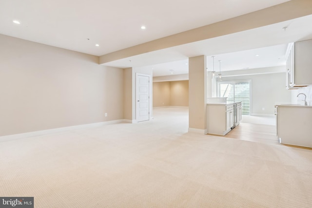 interior space with sink and light colored carpet