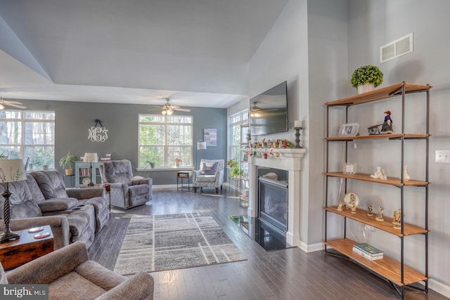 living room featuring ceiling fan, plenty of natural light, and dark hardwood / wood-style floors