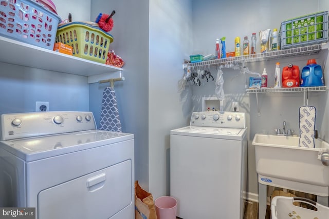 washroom featuring washing machine and dryer and sink