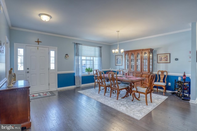 dining area with ornamental molding, an inviting chandelier, and dark hardwood / wood-style floors