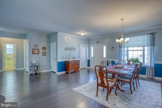 dining area with dark hardwood / wood-style flooring, crown molding, and a notable chandelier