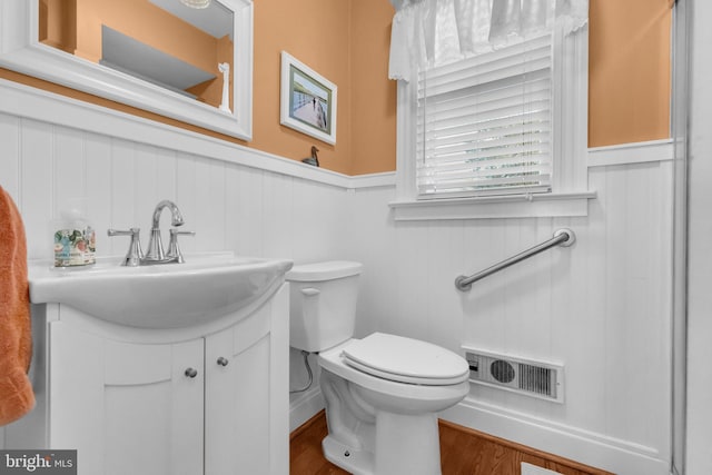 bathroom featuring wood-type flooring, toilet, and vanity