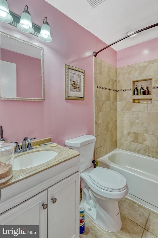 full bathroom featuring toilet, vanity, tile patterned floors, and tiled shower / bath combo