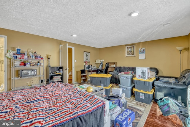 bedroom with a textured ceiling and hardwood / wood-style floors