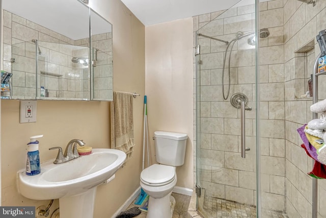 bathroom featuring toilet, walk in shower, tile patterned floors, and sink