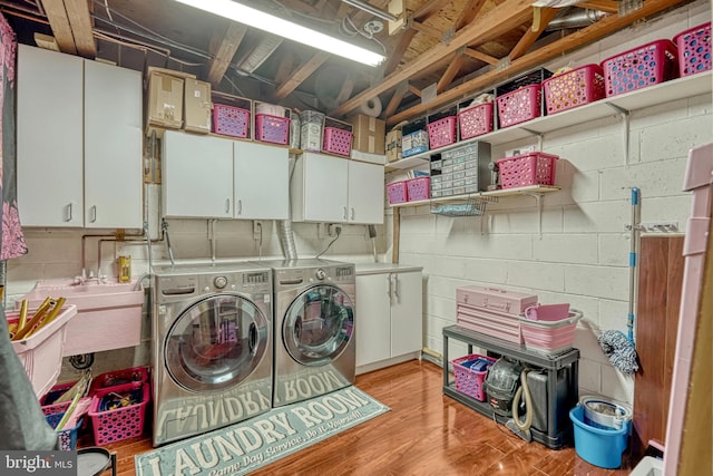 laundry room with cabinets, separate washer and dryer, and sink