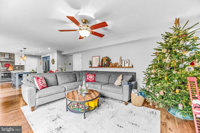 living room with ceiling fan and light hardwood / wood-style flooring