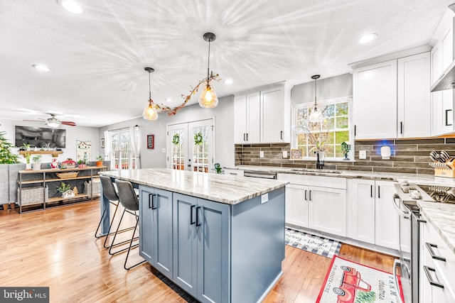 kitchen with decorative light fixtures, a center island, and white cabinetry