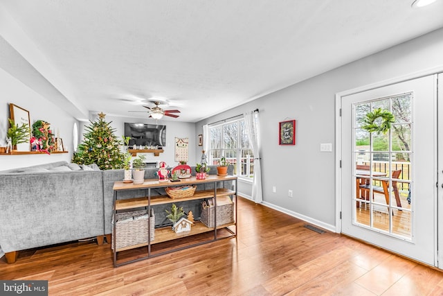 living room featuring light wood-type flooring and ceiling fan