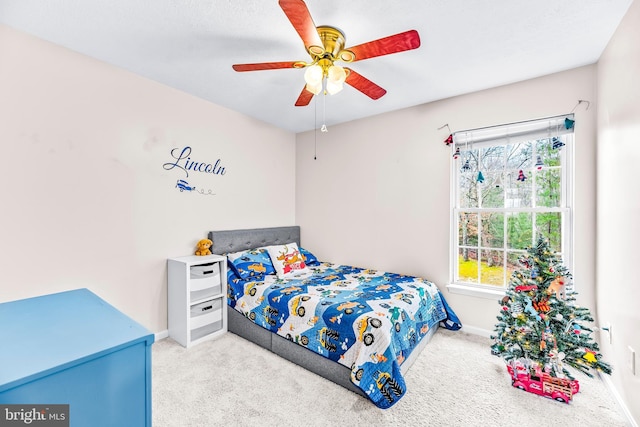 bedroom with multiple windows, ceiling fan, and light colored carpet