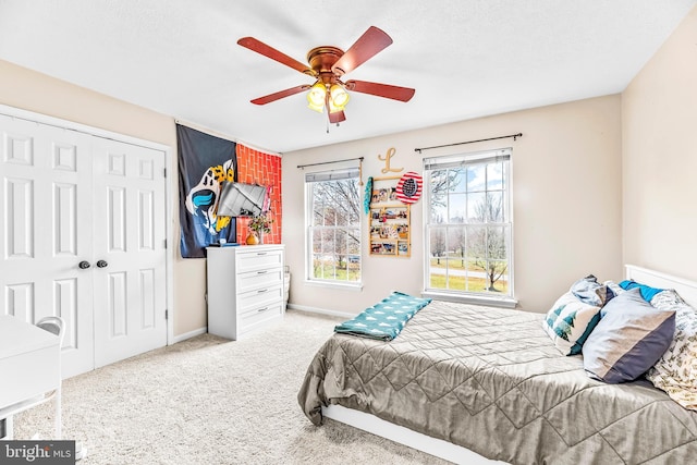 bedroom with light colored carpet, ceiling fan, and a closet