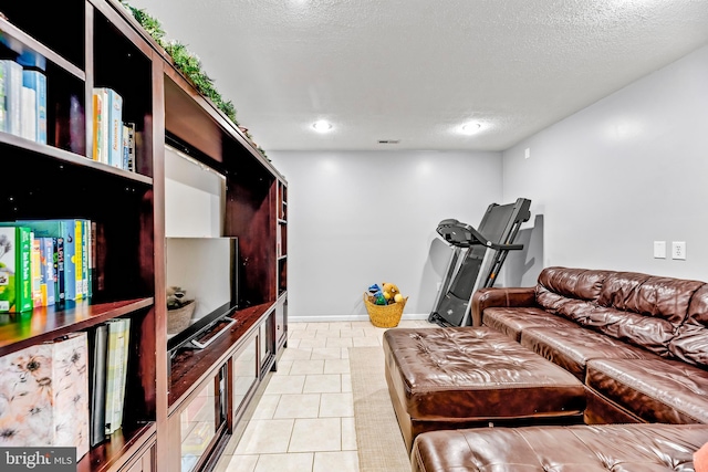 living room with a textured ceiling and light tile patterned floors