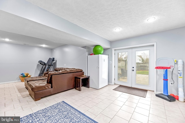 interior space with a textured ceiling and french doors