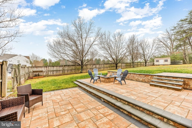 view of patio / terrace featuring an outdoor fire pit and an outbuilding