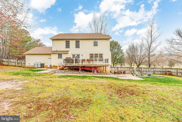 back of property with a patio, a lawn, and a wooden deck