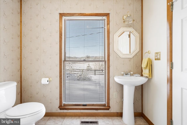 bathroom with toilet, tile patterned flooring, and sink