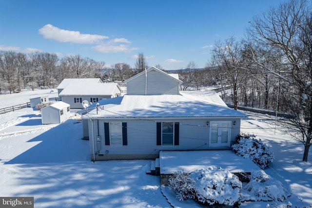 snow covered property featuring a storage unit