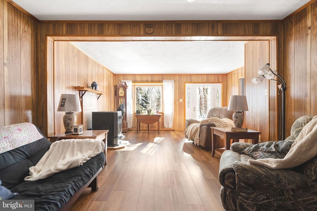 interior space with light hardwood / wood-style floors, a textured ceiling, and wood walls