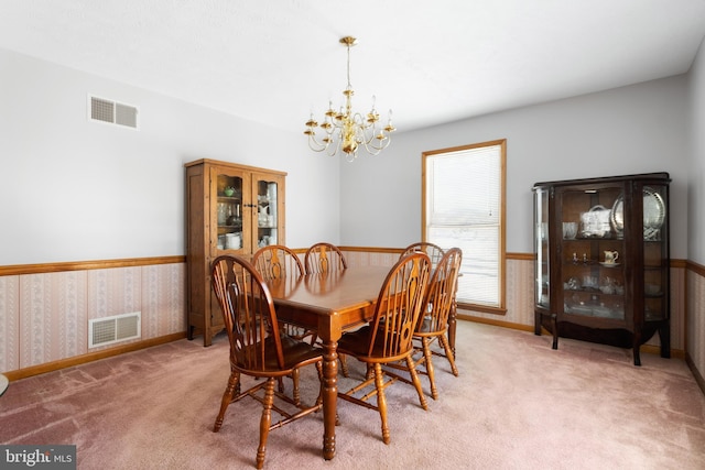 dining space with carpet and a chandelier