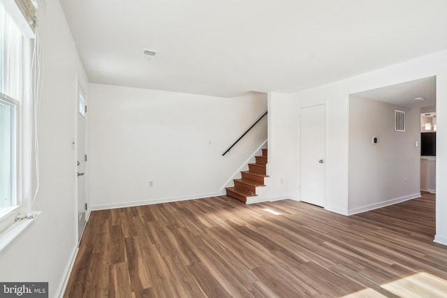 unfurnished room featuring plenty of natural light and dark hardwood / wood-style flooring