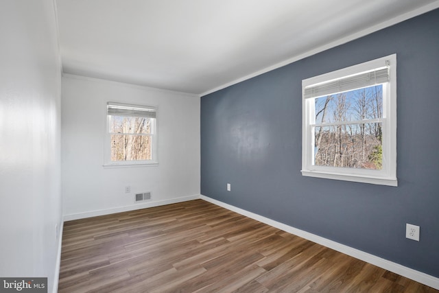 empty room featuring ornamental molding and hardwood / wood-style floors