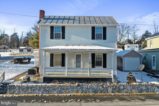 view of front of property featuring covered porch, an outdoor structure, central AC unit, and a garage