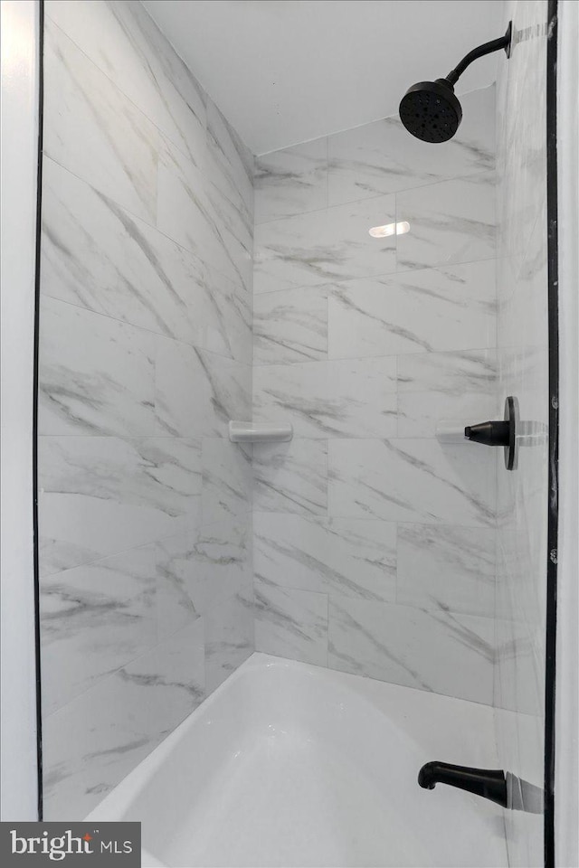 bathroom featuring tiled shower / bath