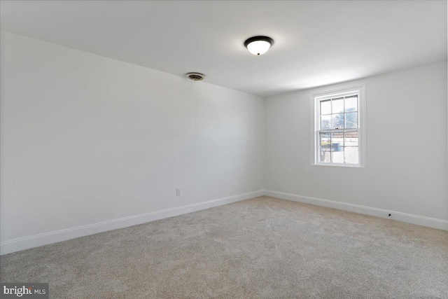 spare room featuring light colored carpet