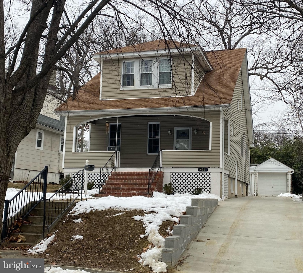 view of front of home featuring a garage, an outdoor structure, and covered porch